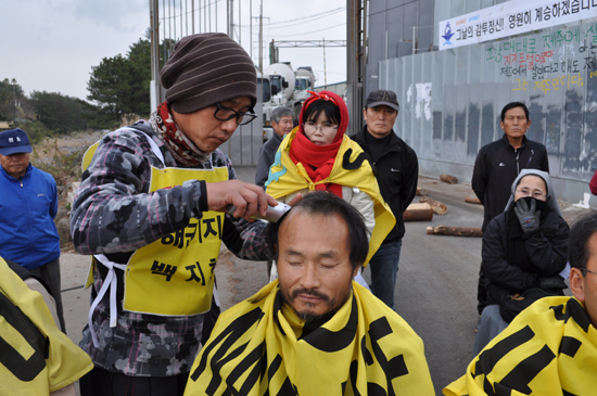 제주해군기지사업단 정문 앞에서 삭발식이 진행되고 있다. / 강정마을회 제공
