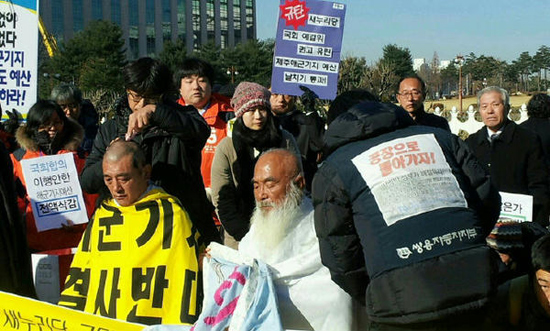 29일 오전 서울 국회의사당 앞에서 강동균 강정마을회장과 문정현 신부 등이 삭발을 하고 있다. / 트위터