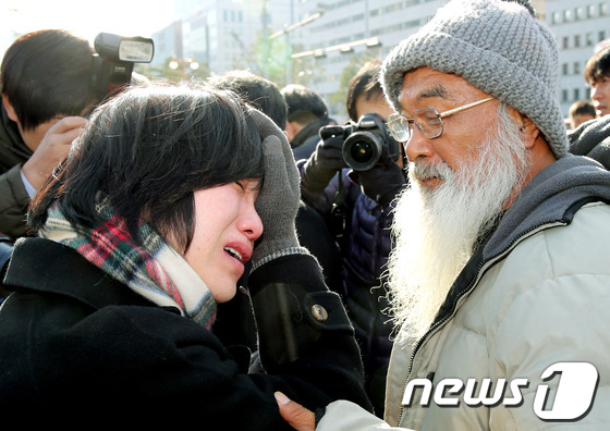 눈물 흘리는 장하나 의원【Joins=News1】민주통합당 장하나 의원이 29일 서울 여의도 국회의사당 앞에서 제주해군기지 예산안 날치기 통과에 항의하며 삭발한 문정현신부 앞에서 눈물을 흘리고 있다. 삭발식에 앞서 제주 강정마을주민과 진보정의당 노회찬 의원, 민주통합당 장하나 의원 등은 국회 국방위원회에서 제주해군기지 예산안을 단독 처리안 새누리당을 비판했다.