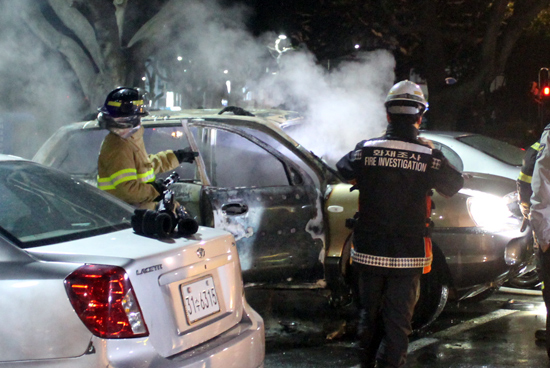 13일 밤 제주시 신제주 인근 주차장에 세워진 차량에서 불이 났다. 소방관들이 불을 끄고 있다.